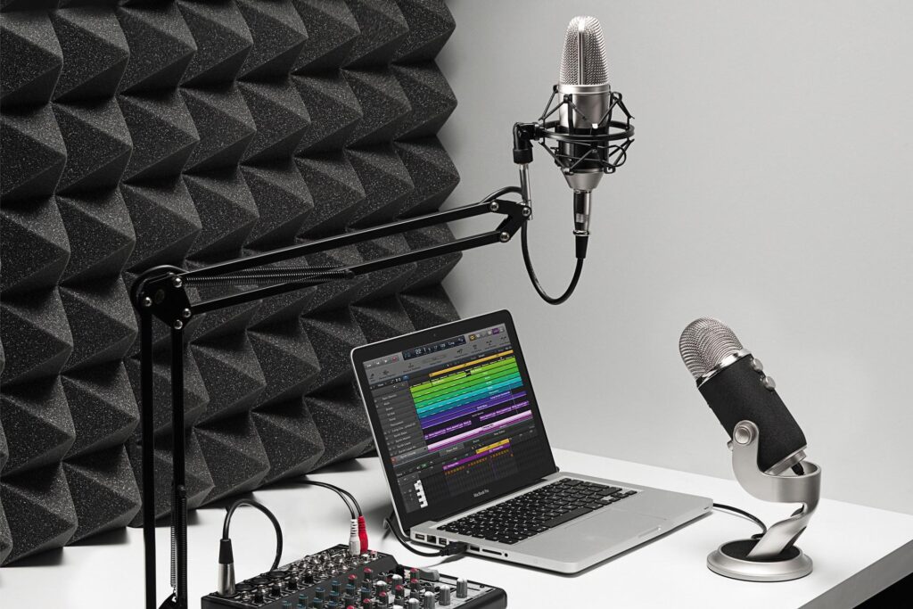 Laptop computer set up with two microphones and an audio mixer for posdcasting production